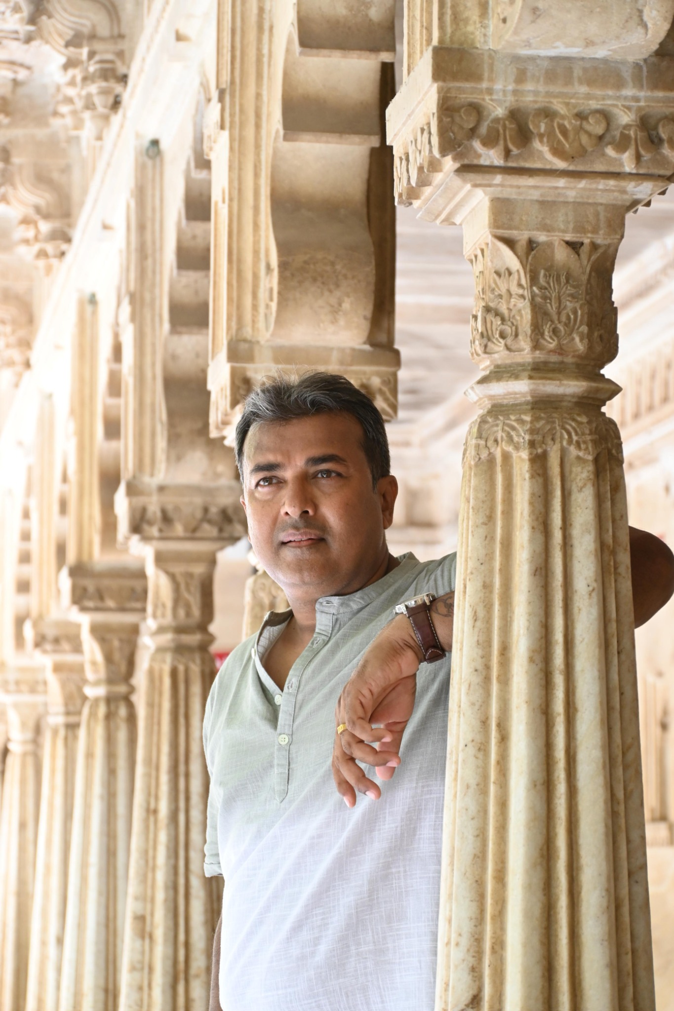 Kumar Rajesh standing among carved stone columns